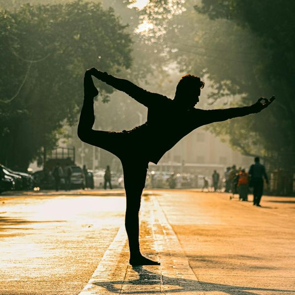 Silhouetted person in a balancing yoga pose